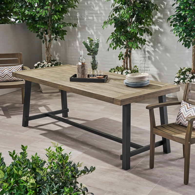 Rustic gray metal outdoor dining table by Noble House, showing a sturdy rectangular table with metal legs and a weathered finish.