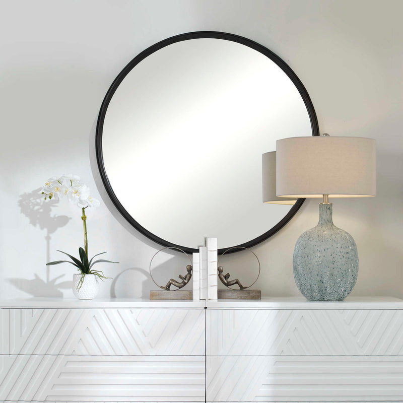 Black round accent mirror by Uttermost with a sleek frame, suitable for modern or contemporary home decor.