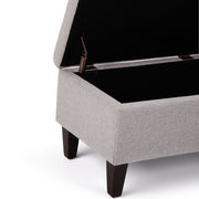 Simpli-Home Monroe upholstered storage ottoman with soft fabric and built-in storage, shown from a front angle.