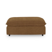 Classic Home Caplan upholstered ottoman with a cushioned top and wooden legs, ideal for living room or bedroom decor.