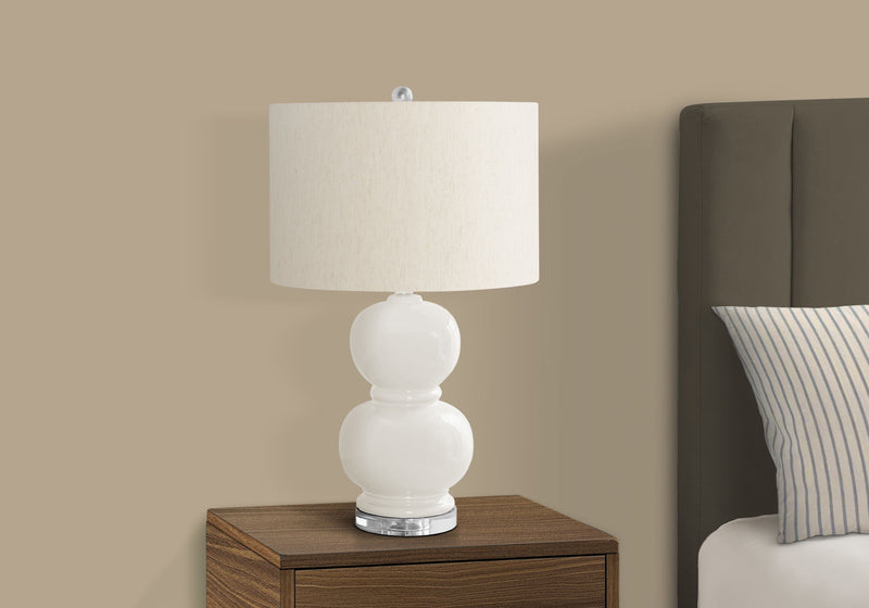 Modern 8th Street contemporary table lamp with sleek design, featuring a white shade and metallic base, on a wooden surface.