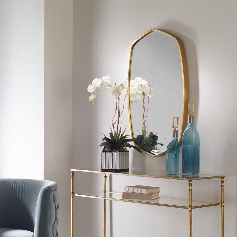 Uttermost Duronia iron wall mirror with a sleek, modern frame hanging on a wall, reflecting a minimalistic interior.