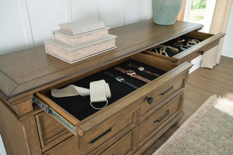 Signature Design by Ashley Karallin dresser with dark wood finish, featuring multiple drawers and sleek modern handles.