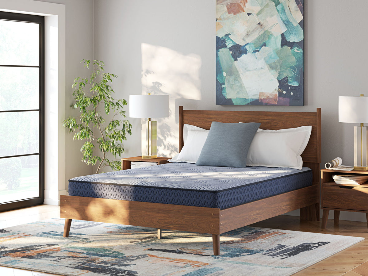 Sierra Sleep® by Ashley Peak 2.0 Bonnell hybrid mattress with quilted top and supportive coils, shown in a bedroom setting.