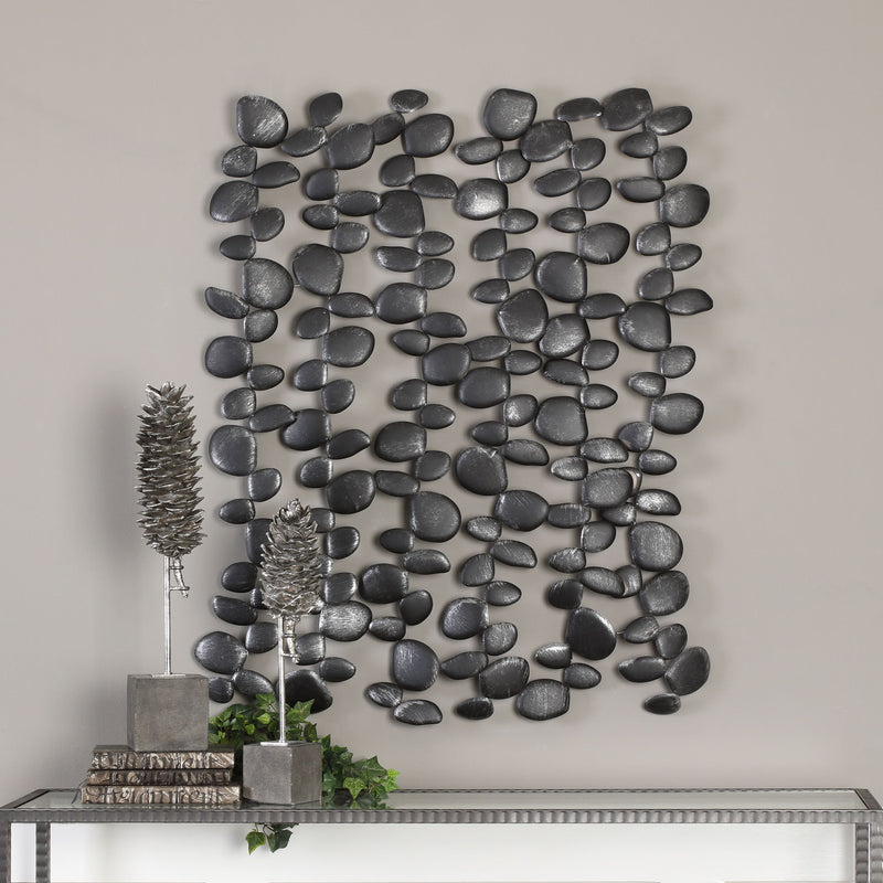 Black forged iron wall art featuring stacked skipping stones design by Uttermost, ideal for modern wall decor.