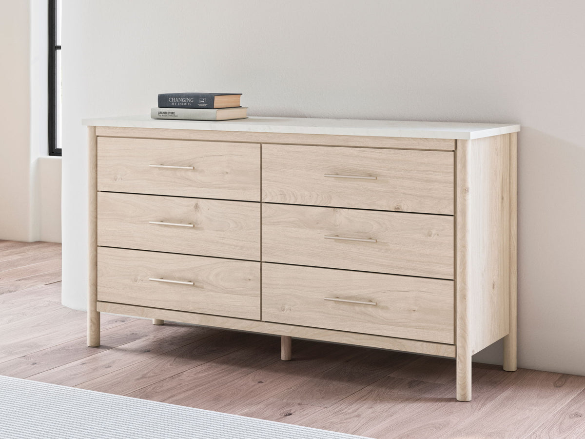 Signature Design by Ashley Cadmori six-drawer dresser with wood finish and modern style, featuring sleek metal handles.