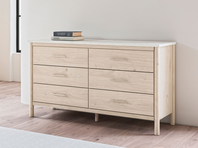 Signature Design by Ashley Cadmori six-drawer dresser with wood finish and modern style, featuring sleek metal handles.