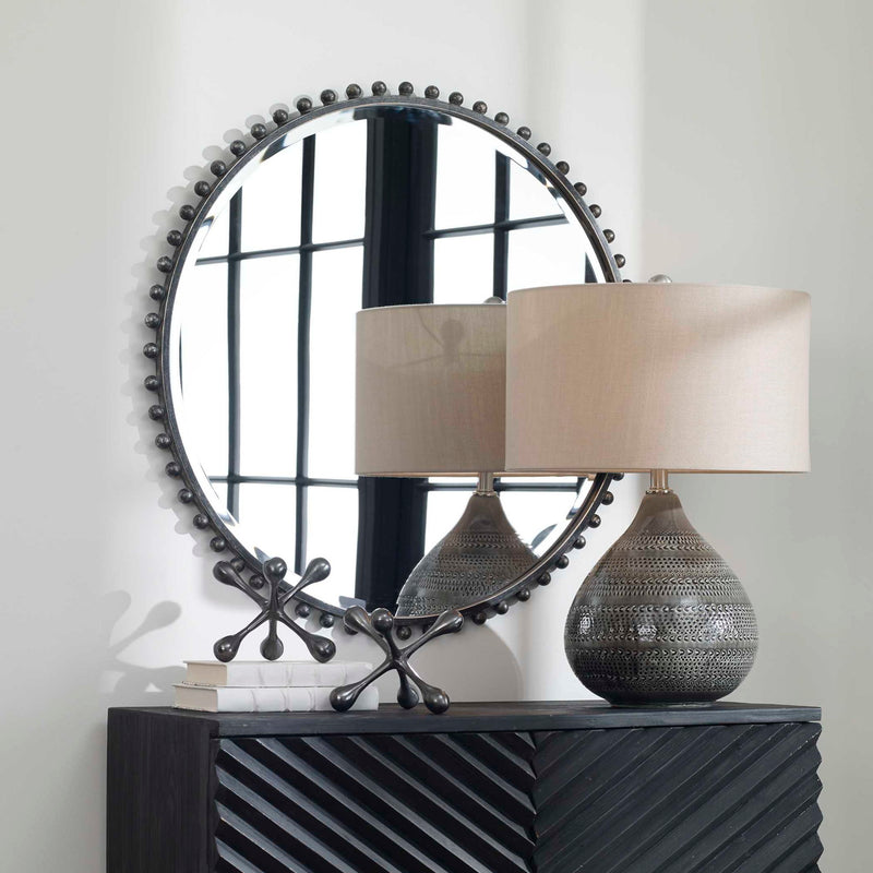 Round iron wall mirror by Uttermost featuring a sleek, minimalist design with a sturdy metal frame.