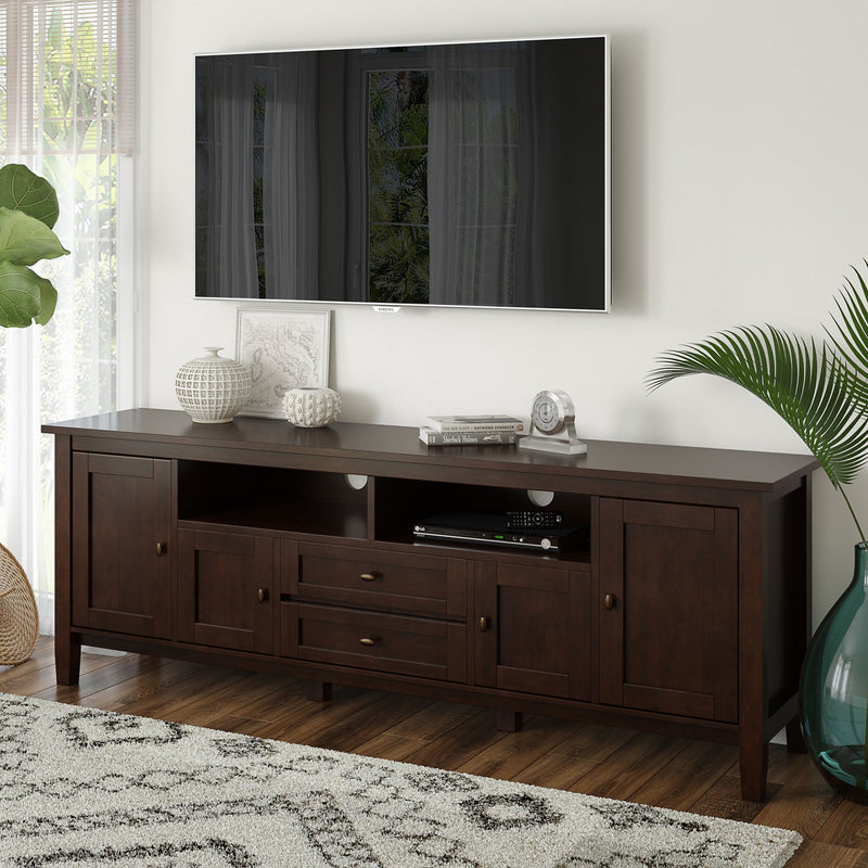 Handcrafted Warm Shaker TV media stand by Simpli-Home with open shelves and storage compartments, made of warm-toned wood.