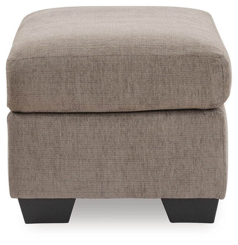 Upholstered Ottoman from Benchcraft® Loreo collection, featuring plush fabric and sturdy wooden legs, perfect for living room use.