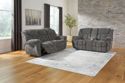 Signature Design by Ashley reclining living room set with plush sofas and loveseats, featuring padded armrests and reclining mechanisms.