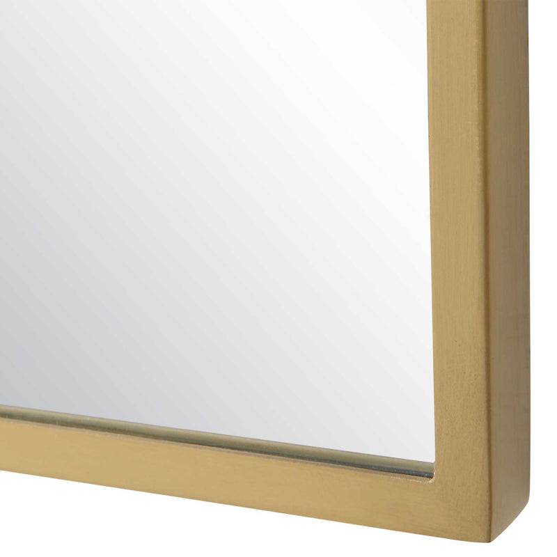 Tall brass wall mirror by Uttermost, Caddington design with sleek frame, reflecting light and adding elegance to the space.