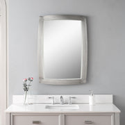 Uttermost Haskill brushed nickel wall mirror with a sleek, modern design and round shape, mounted on a wall.
