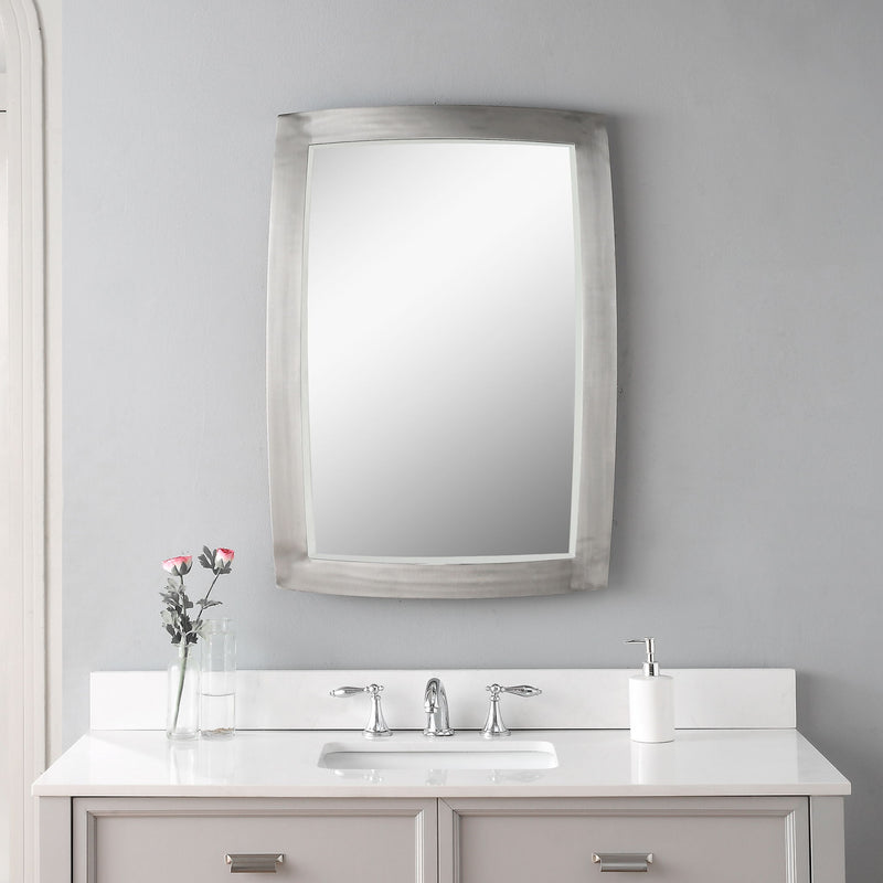 Uttermost Haskill brushed nickel wall mirror with a sleek, modern design and round shape, mounted on a wall.