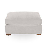 Classic Home Audrey upholstered ottoman with a tufted fabric top and wooden legs, showcasing elegant and comfortable design.
