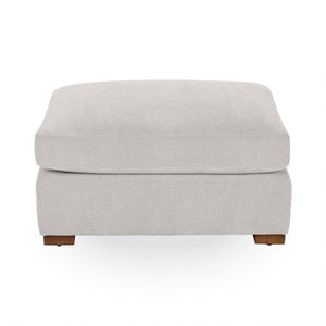 Classic Home Audrey upholstered ottoman with a tufted fabric top and wooden legs, showcasing elegant and comfortable design.