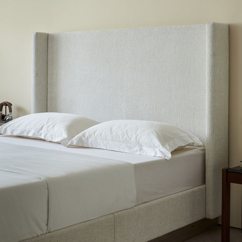 House & Home Furniture Hosford minimalist upholstered wingback bed with wood base platform in a modern bedroom setting.
