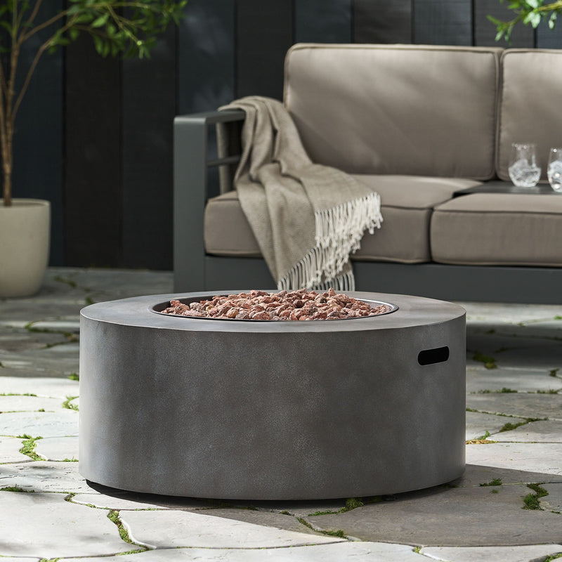 Round iron fire pit by Noble House with 40,000 Btu, featuring a sturdy design and open flame area for outdoor heating and ambiance.
