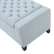 Noble House Guernsey storage ottoman with tufted top, beige fabric, and wooden legs, serving as a stylish indoor storage solution.