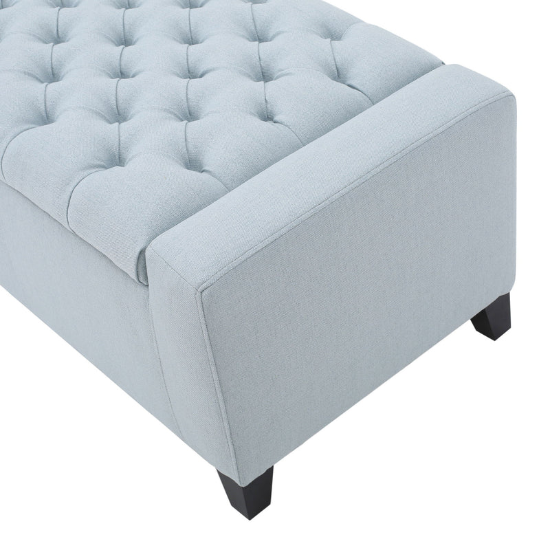 Noble House Guernsey storage ottoman with tufted top, beige fabric, and wooden legs, serving as a stylish indoor storage solution.