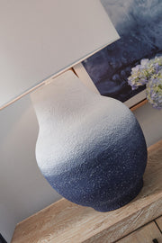 White and navy metal table lamp from Dashland by Signature Design Ashley, featuring a sleek modern design.