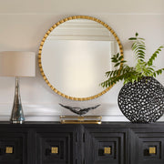 Round industrial wall mirror by Uttermost, showcasing a metal frame and reflective glass surface for modern decor.