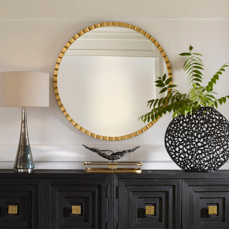 Round industrial wall mirror by Uttermost, showcasing a metal frame and reflective glass surface for modern decor.