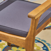 Set of two Noble House outdoor dining chairs with slat back design and acacia wood frames in gray and teak finishes.