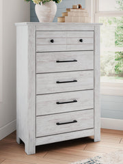 Signature Design by Ashley Makidern five-drawer accent chest with wood finish and modern hardware, standing on four sturdy legs.