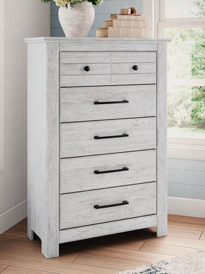Signature Design by Ashley Makidern five-drawer accent chest with wood finish and modern hardware, standing on four sturdy legs.