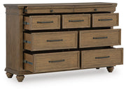 Signature Design by Ashley Karallin dresser with sleek wood finish and modern hardware, featuring multiple drawers for storage.