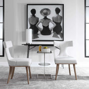 Set of two white Klismos accent chairs by Uttermost with sleek wooden legs and curved backrests, ideal for stylish living spaces.