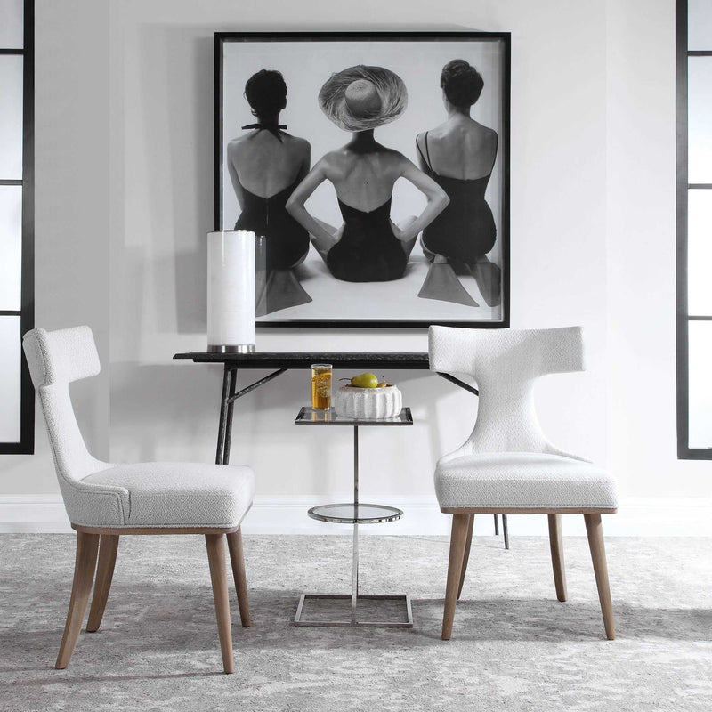 Set of two white Klismos accent chairs by Uttermost with sleek wooden legs and curved backrests, ideal for stylish living spaces.