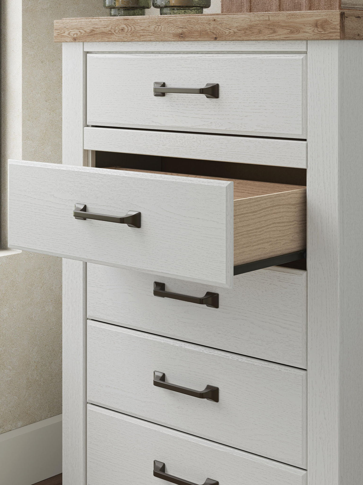 Benchcraft® Savonport five-drawer accent chest in white and brown with sleek drawer handles and modern design.