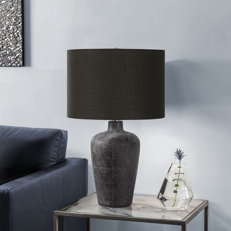 Contemporary black 8th Street table lamp with a sleek design, featuring a round base and cylindrical shade on a modern table.
