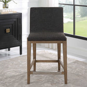 Uttermost Klemens counter stool with wooden legs and upholstered seat, 24-27 inch height, modern design for kitchen or bar area.