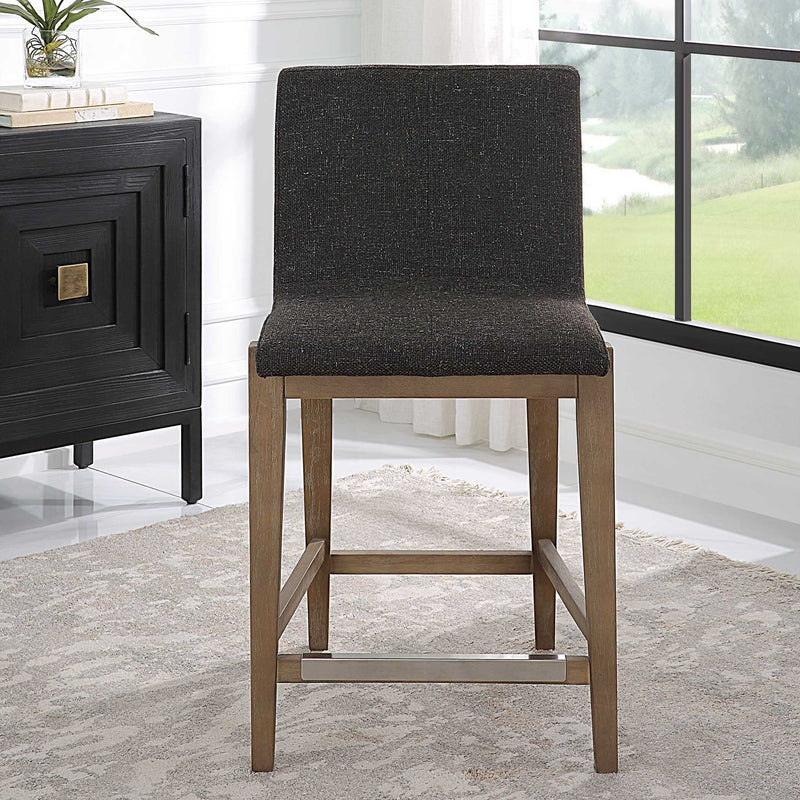 Uttermost Klemens counter stool with wooden legs and upholstered seat, 24-27 inch height, modern design for kitchen or bar area.