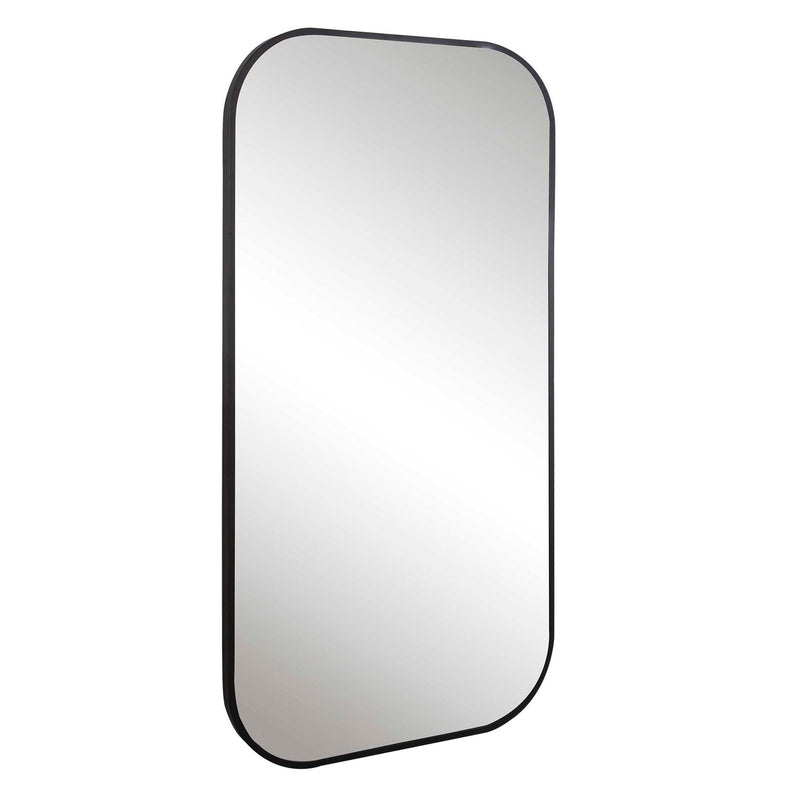 Uttermost Taft wall mirror with a sleek, modern frame, hanging on a wall, reflecting a stylish interior.