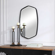 Uttermost Duronia iron wall mirror with a sleek, modern design and round shape, mounted on a plain background.