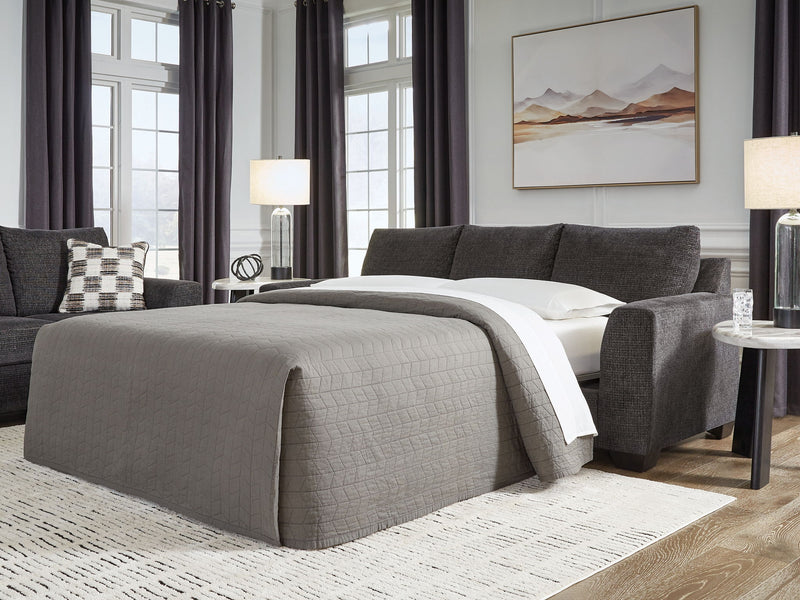 Benchcraft® Loreo sofa sleeper with plush fabric and convertible design, shown with unfolded bed in a modern living room setting.