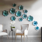 Set of three blue ceramic flower wall decor pieces by Uttermost, featuring detailed flower designs for elegant home decoration.