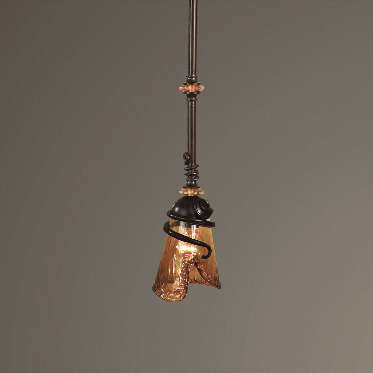 Uttermost Vitalia mini pendant light in oil rubbed bronze with a sleek, modern design hanging from a ceiling fixture.