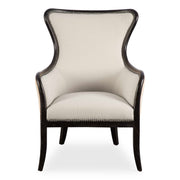 Uttermost Sandy wing back armchair in beige and dark brown fabric with plush cushioning and wooden legs.