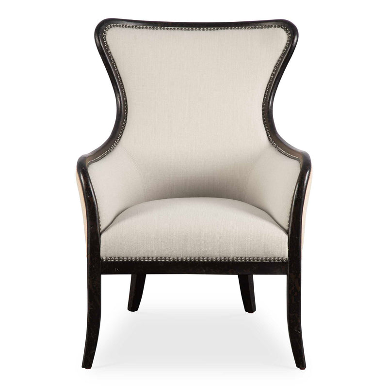 Uttermost Sandy wing back armchair in beige and dark brown fabric with plush cushioning and wooden legs.