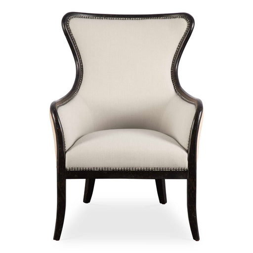 Uttermost Sandy wing back armchair in beige and dark brown fabric with plush cushioning and wooden legs.