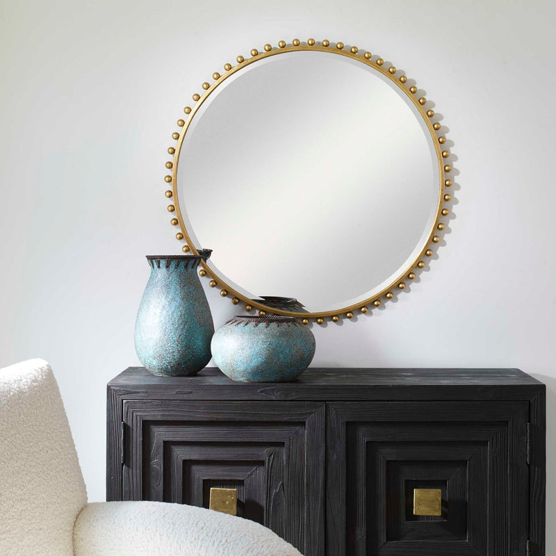 Round iron wall mirror by Uttermost with a minimalist design, featuring a sleek black frame and reflective surface.