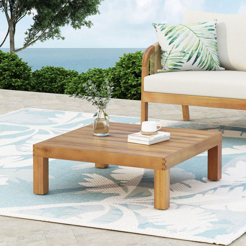 Noble House Mythical square outdoor coffee table with teak frame and slat top, designed for stylish patio or garden seating areas.
