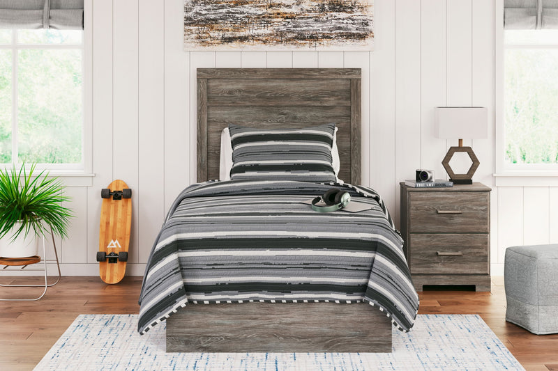 Signature Design by Ashley Ralinksi panel bed with a sleek wooden frame and modern headboard, shown in a cozy bedroom setting.