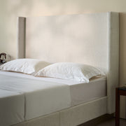 House & Home Furniture Hosford minimalist upholstered wingback bed with wood platform base, showcasing plush fabric and elegant design.