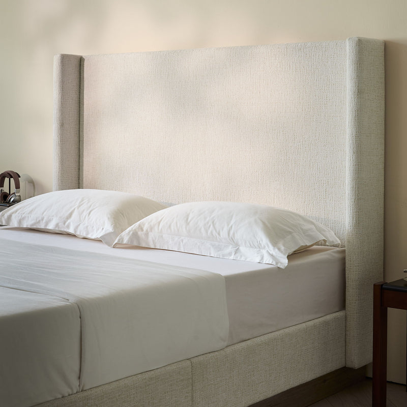 House & Home Furniture Hosford minimalist upholstered wingback bed with wood platform base, showcasing plush fabric and elegant design.